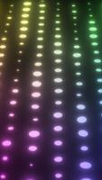 Vertical rows of softly glowing oval lights in a gradient rainbow spectrum against a dark blurred background video