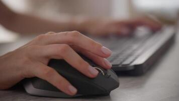 fechar-se do mão usando uma computador rato enquanto digitando em uma teclado video