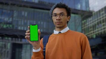 Man showing green screen smartphone and shaking head in disapproval video