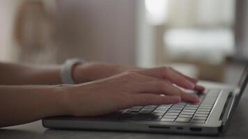Hands typing on a laptop in a cozy home setting video