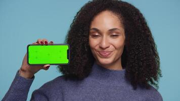 Smiling woman nodding in approval and showing green screen phone video