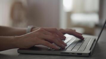 Side View of Hands Typing on a Laptop Keyboard in a Dimly Lit Room video