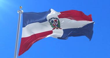Flag of the Dominican Republic waving at wind with blue sky in slow, loop video