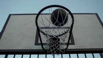 The ball finally makes its way into the basketball hoop after bouncing and ricocheting several times. Close up. video