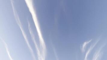 White lines after flying airplane in blue sky at summer sunny day.Beautiful cloudscape at background. Close up Slow motion video