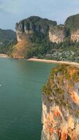 Aerial view of Railay Beach in Krabi, Thailand. Emerald sea, white sand beach, and towering limestone cliffs create scenic tropical paradise. video