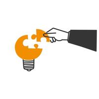 a hand is holding a puzzle piece to a light bulb vector