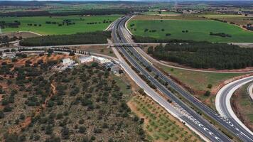 Highway cutting through green farmland with overpass and rural infrastructure video