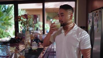 Relaxed scenes of man sipping homemade matcha latte at home. Natural lifestyle moments showing calmness, daily ritual, and enjoyment of a traditional green tea drink smiling video