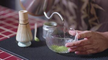 Preparing Matcha Tea Latte at home from measuring, whisking with a bamboo chasen, and pouring into a glass, capturing the soothing ritual of making this traditional Japanese drink. pour hot water video