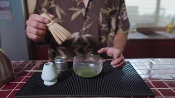 Preparing Matcha Tea Latte at home from measuring, whisking with a bamboo chasen, and pouring into a glass, capturing the soothing ritual of making this traditional Japanese drink. mix it video