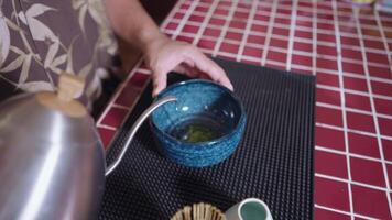 Preparing Matcha Tea Latte at home from measuring, whisking with a bamboo chasen, and pouring into a glass, capturing the soothing ritual of making this traditional Japanese drink. hot water video