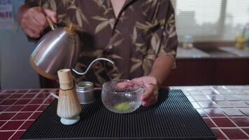 Preparing Matcha Tea Latte at home from measuring, whisking with a bamboo chasen, and pouring into a glass, capturing the soothing ritual of making this traditional Japanese drink. pouring water video