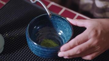 Preparing Matcha Tea Latte at home from measuring, whisking with a bamboo chasen, and pouring into a glass, capturing the soothing ritual of making this traditional Japanese drink. water to powder video