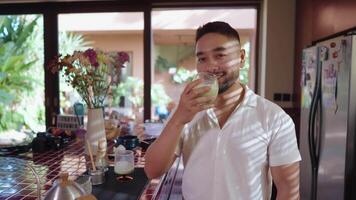 Relaxed scenes of man sipping homemade matcha latte at home. Natural lifestyle moments showing calmness, daily ritual, and enjoyment of a traditional green tea drink smile video