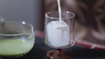 Preparing Matcha Tea Latte at home from measuring, whisking with a bamboo chasen, and pouring into a glass, capturing the soothing ritual of making this traditional Japanese drink milk video