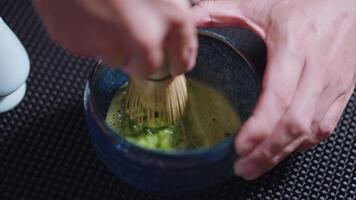 Preparing Matcha Tea Latte at home from measuring, whisking with a bamboo chasen, and pouring into a glass, capturing the soothing ritual of making this traditional Japanese drink. hand mixing video