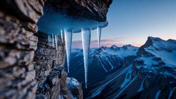 Icicles Hanging From Rock Face with Snowy Mountain View photo