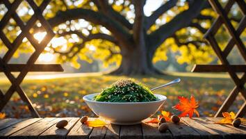 Green Salad in Bowl on Wooden Table with Autumnal Setting photo