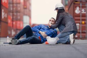 First aid for a container warehouse worker fainted while working in the bright sunlight and hot weather of a container storage yard,153 photo