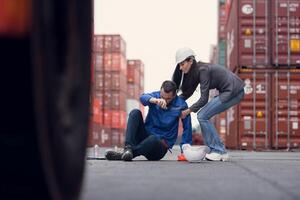 First aid for a container warehouse worker fainted while working in the bright sunlight and hot weather of a container storage yard,150 photo