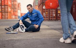 First aid for a container warehouse worker fainted while working in the bright sunlight and hot weather of a container storage yard,130 photo