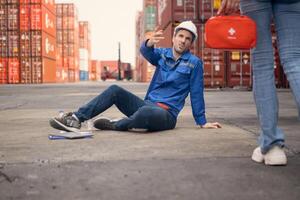 First aid for a container warehouse worker fainted while working in the bright sunlight and hot weather of a container storage yard,116 photo
