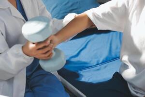 A nurse is helping a patient with a dumbbell photo