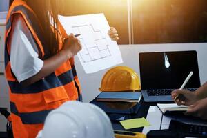 A man and woman in hard hats and safety vests are working on a project photo