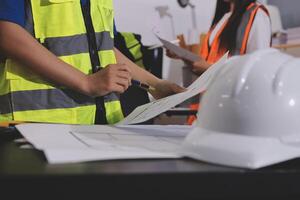 A man in a hard hat and vest is holding a piece of paper photo