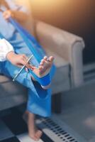 A person sitting on a couch with a blue bandage on their foot photo