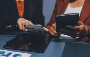 Two business people using their smartphones at a desk photo