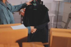 A woman is holding a black jacket in a room photo