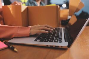 A person typing on a laptop computer with boxes around them photo