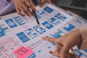 A group of people working on a design document photo