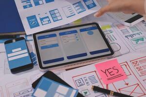 A person is using a tablet to design a mobile app photo