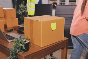 A woman is standing next to a desk with boxes photo