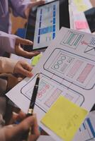 A group of people are working on a project with paper and sticky notes photo