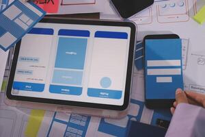 A person using a tablet and a smartphone to design a mobile app photo