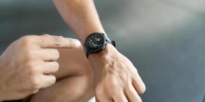 Smartwatch Usage. Man interacting with fitness watch after workout. photo
