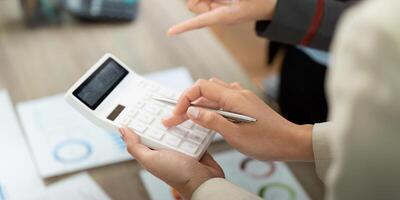 Financial Analysis and Calculation. Professionals using calculator for project budgeting. photo