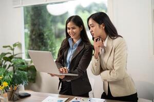 Engaging Business Discussion. Team reviewing data on a laptop in a modern office. photo