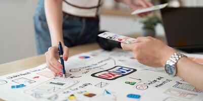 Hands on Design Session. Young professionals collaborating on UX UI concepts with sketches and digital tools. photo