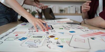 las manos en ux ui diseño taller. Participantes atractivo con diseño elementos. foto