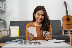 Budgeting and Financial Planning. Woman smiling while reviewing receipts and credit cards. photo