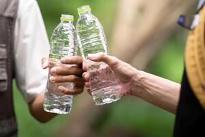 Sharing Hydration. Father and Son Exchanging Water Bottles photo