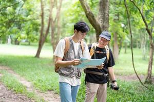 Navigating Nature Together. Father and son reading a map while hiking. photo
