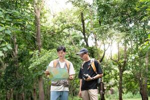 Navigating Nature. Father and Son Studying a Map While Hiking photo