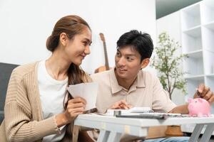 Financial Awareness and Connection. Couple sharing smiles while reviewing savings at home. photo