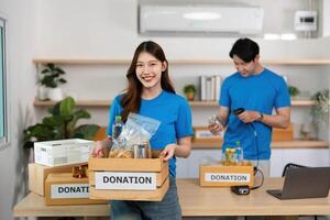 Charitable Giving. Volunteer presenting donation items with a joyful expression. photo